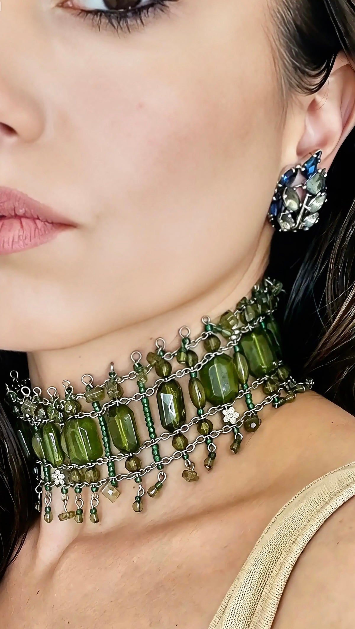 Model wearing sapphire and sage crystal leaf earrings with a green-stone choker